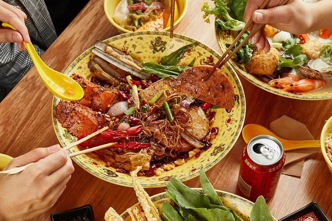 diners dig into a big bowl of hot pot at Dragon Hot Pot
